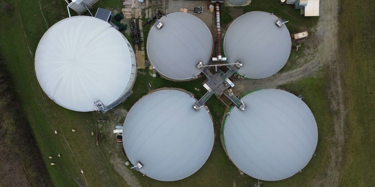 MS aproveita só 6,5% do biometano que poderia extrair da vinhaça das usinas 1 Grandes tanques brancos de biodigestão em meio a um campo verde