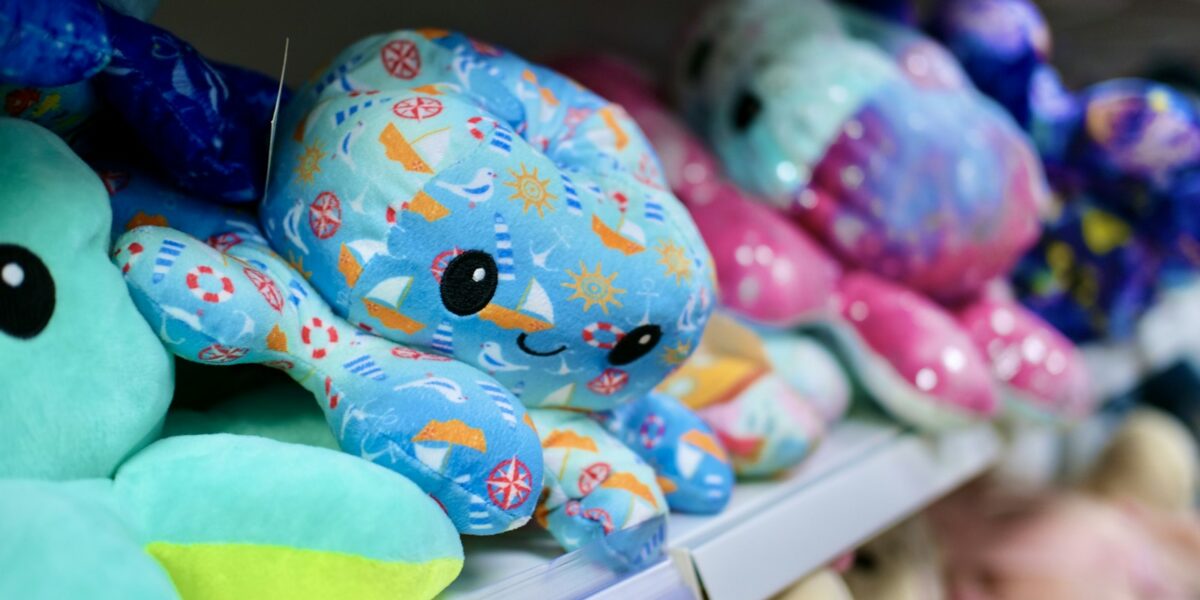 Brinquedos de pelúcia coloridos expostos na prateleira de uma loja de varejo