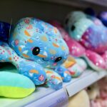Brinquedos de pelúcia coloridos expostos na prateleira de uma loja de varejo