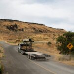 Caminhão de carga trafega por rodovia em região de relevo elevado