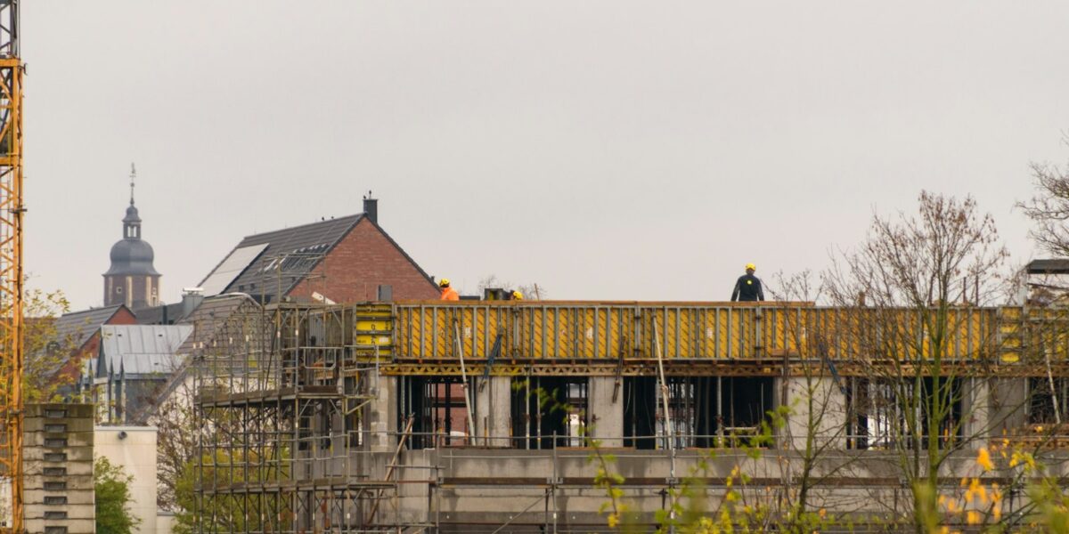 Canteiro de obras com trabalhadores e guindaste
