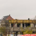 Canteiro de obras com trabalhadores e guindaste