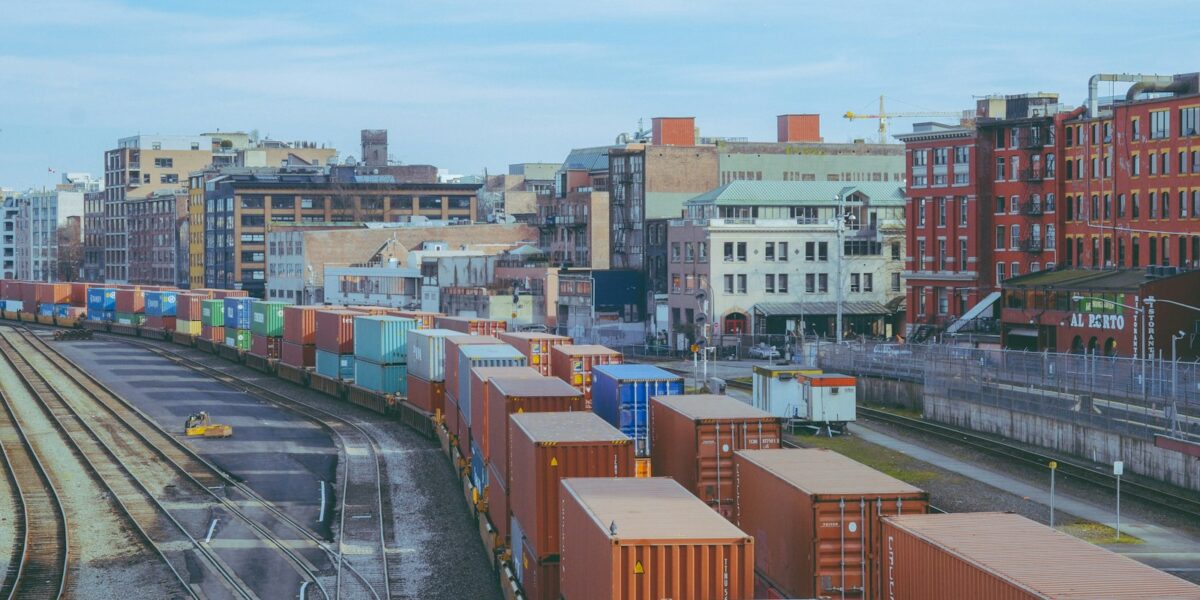 Pátio ferroviário com diversos vagões de carga estacionados nos trilhos