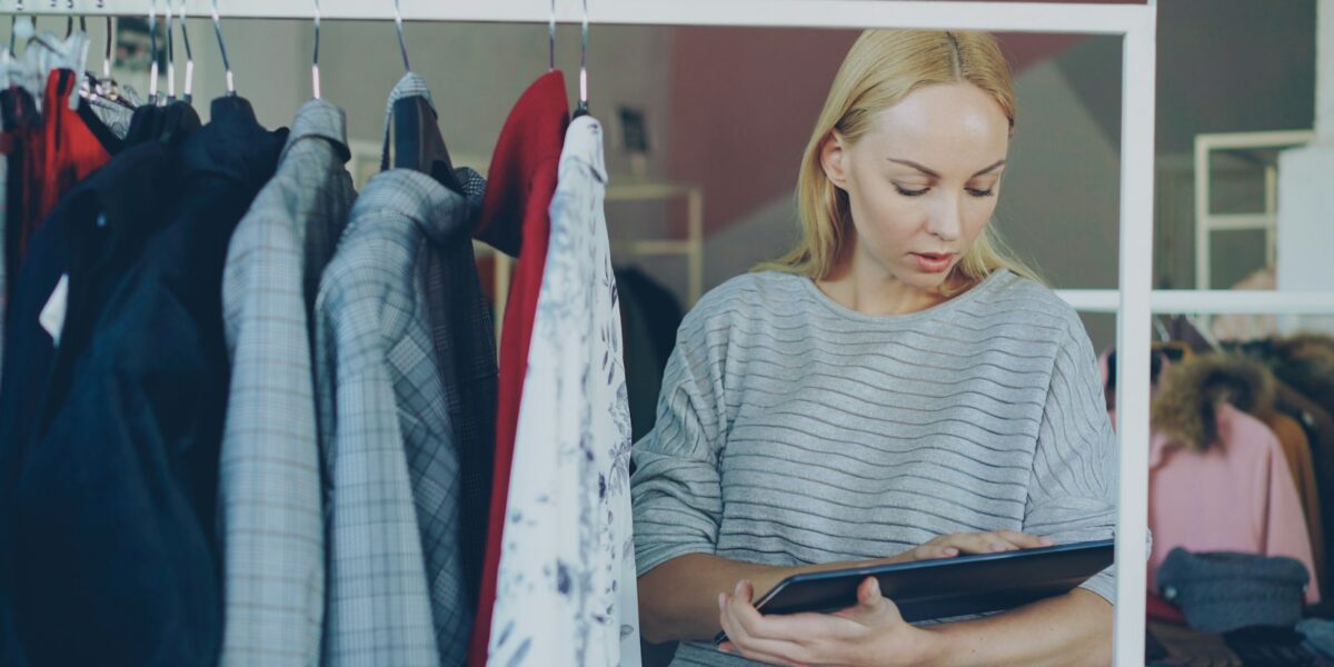 Mulher analisa o estoque em uma loja de roupas