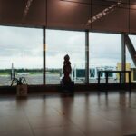 Saguão de aeroporto com vista para a pista e aeronaves
