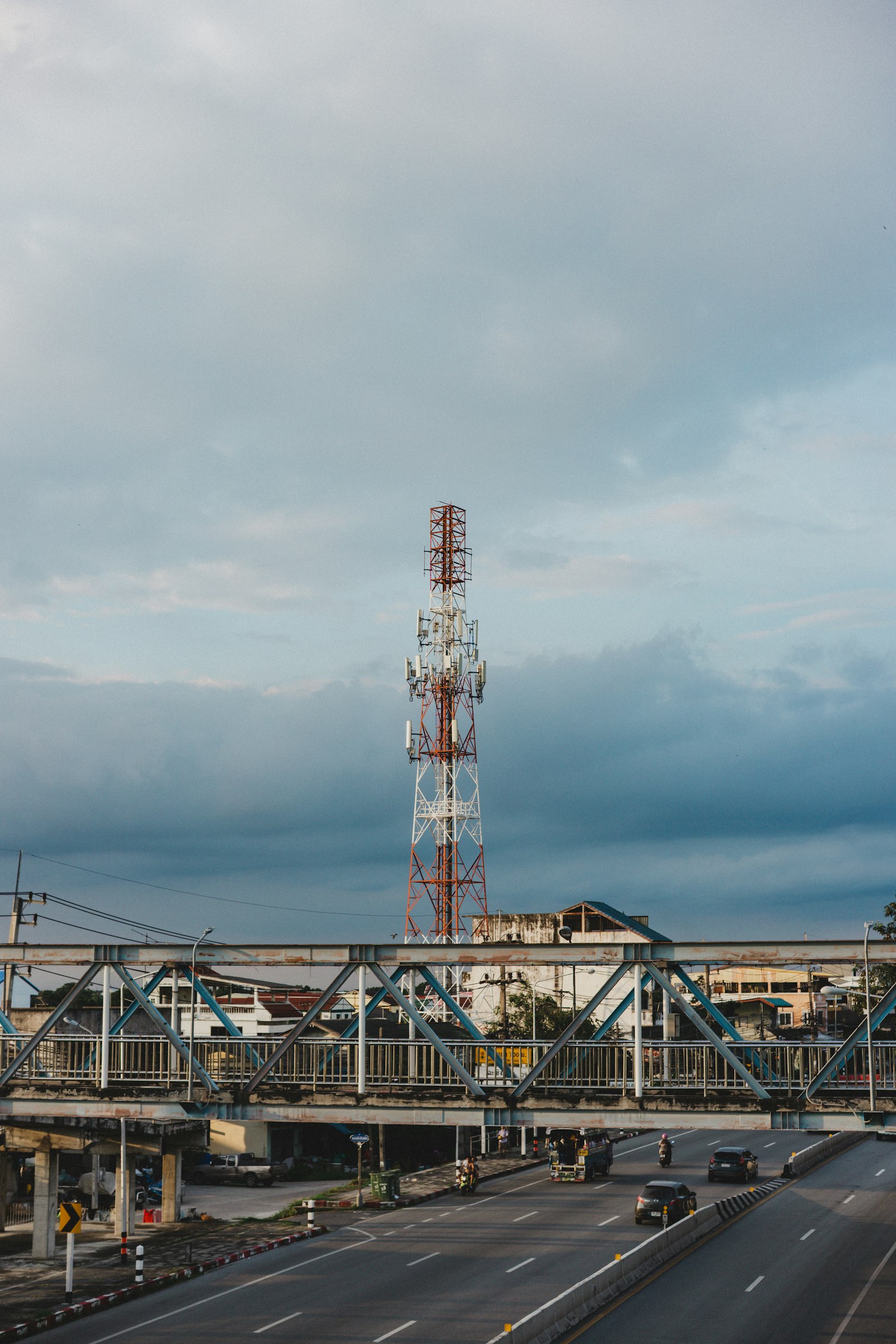 Torre de telefonia celular instalada atrás de uma ponte sobre rodovia