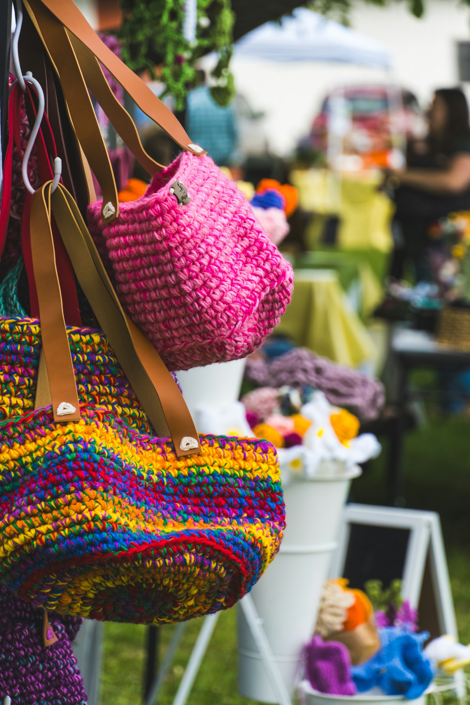 Bolsas de crochê feitas à mão expostas em feira ao ar livre