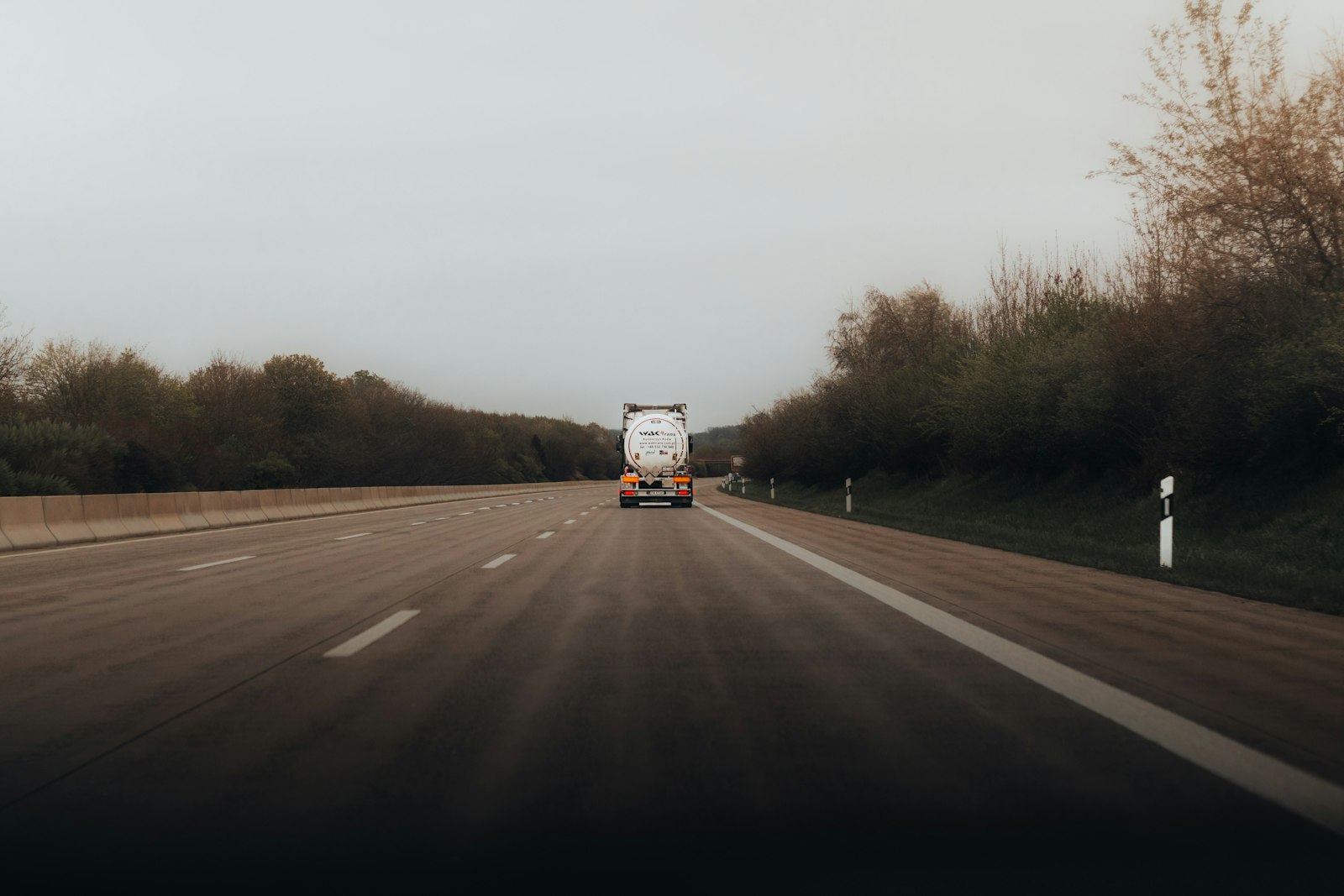 Caminhão de carga trafegando por rodovia ladeada por árvores