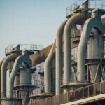 Fileira de tubos metálicos em edifício industrial sob o céu