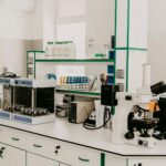 Bancada de laboratório com microscópio e equipamentos analíticos em sala iluminada