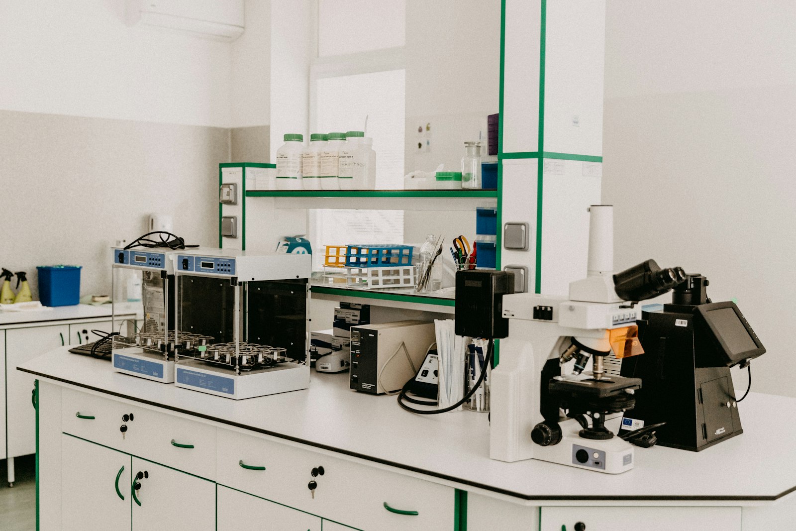Bancada de laboratório com microscópio e equipamentos analíticos em sala iluminada