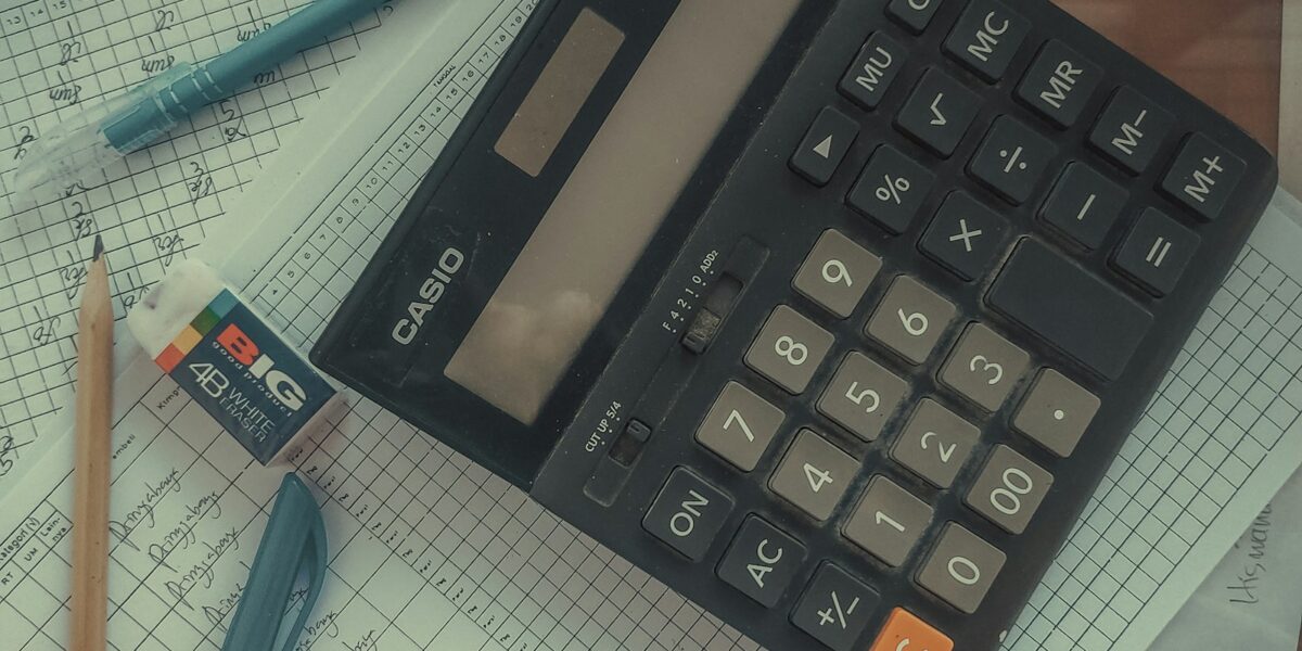 Calculadora apoiada sobre uma pilha de papéis e documentos