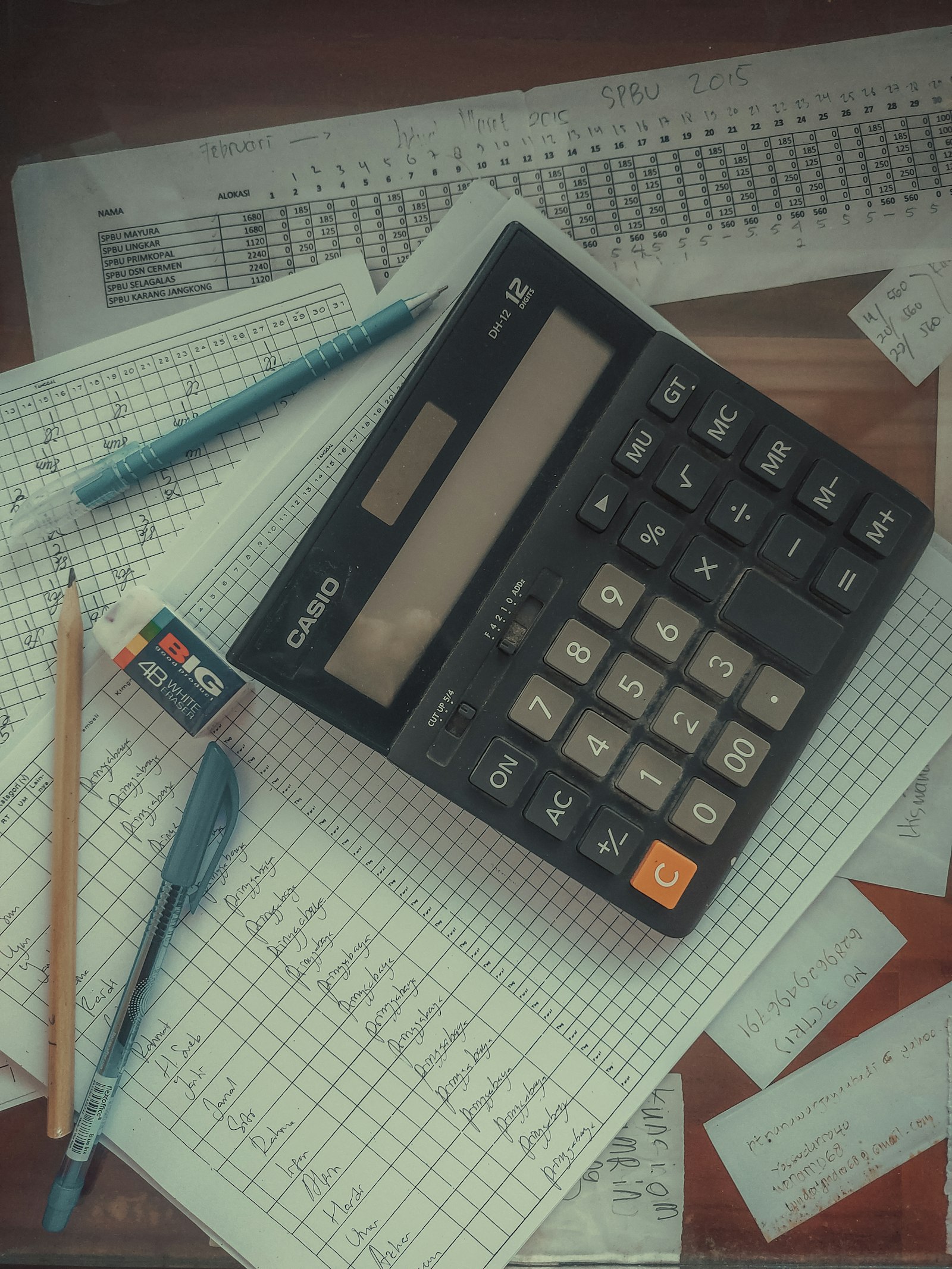 Calculadora apoiada sobre uma pilha de papéis e documentos