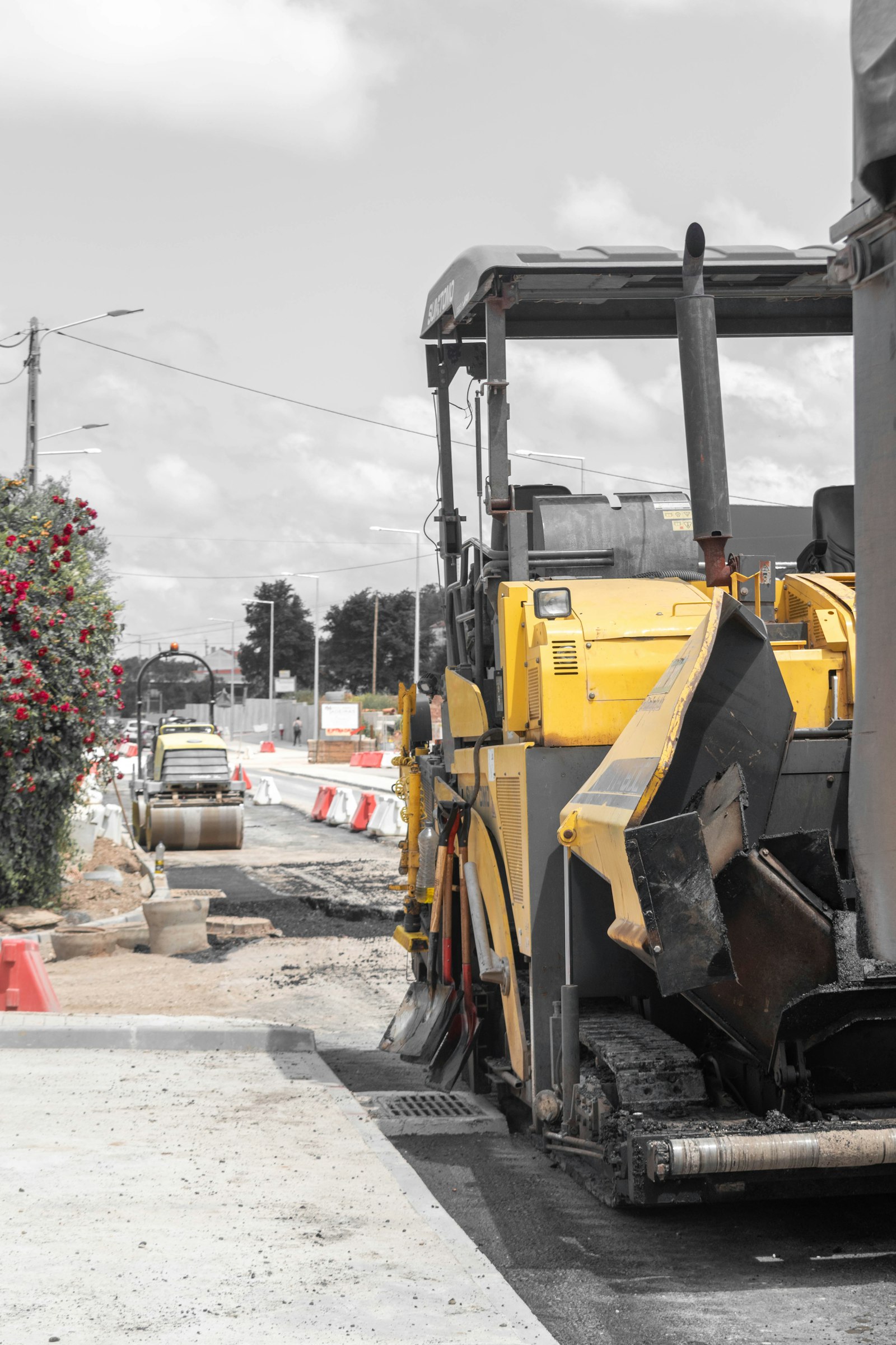 Pavimentadora de asfalto amarela e rolo compressor em obra de rodovia