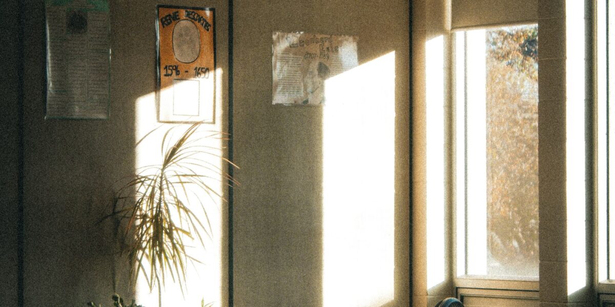 Luz do sol entrando em sala de aula vazia com carteiras escolares