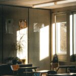Luz do sol entrando em sala de aula vazia com carteiras escolares