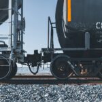 Locomotiva preta e amarela puxando composição de carga sobre trilhos